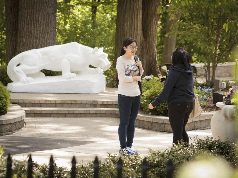 students talking in front of Lion Shrine